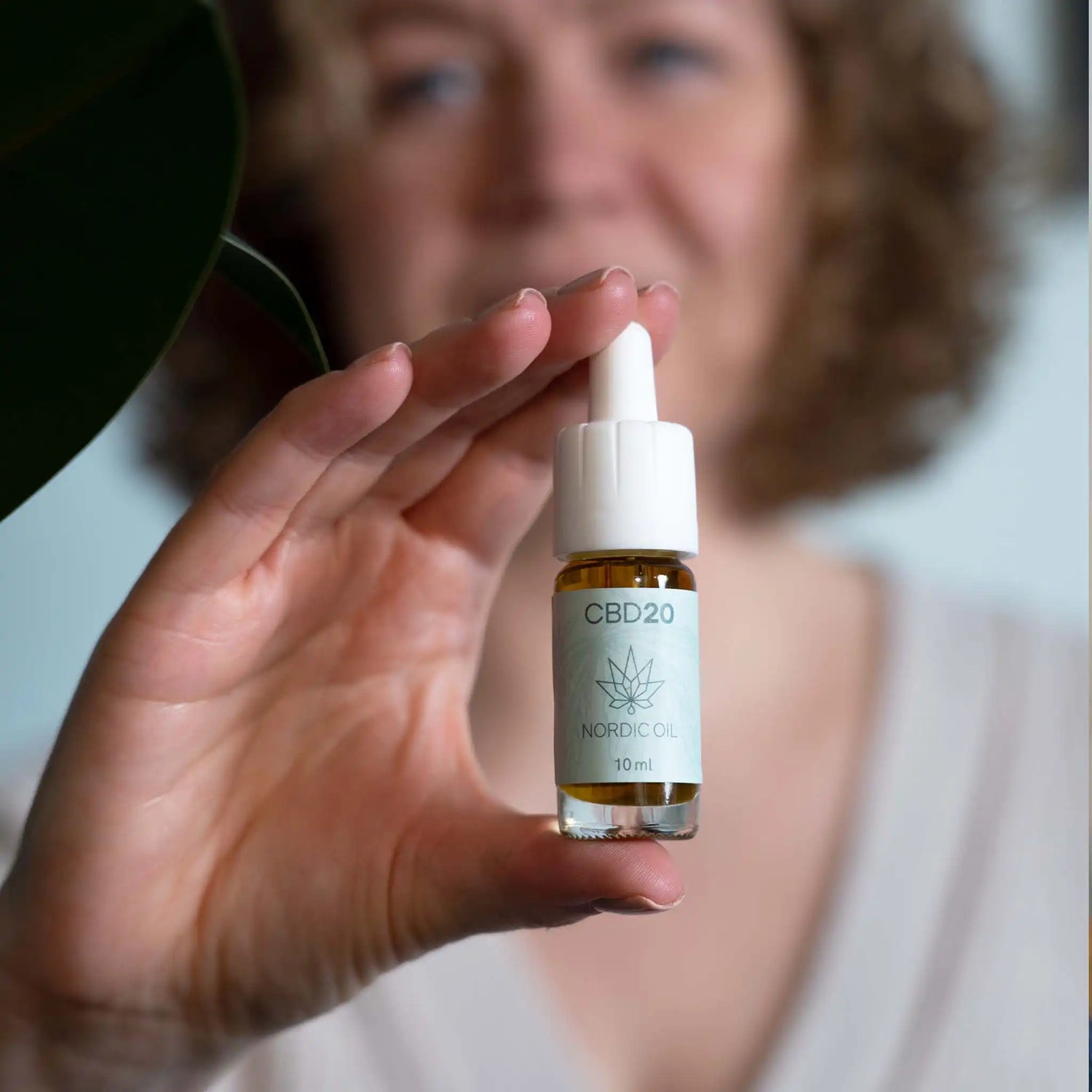 Kvinna som håller en flaska CBD-aroma oil 20%