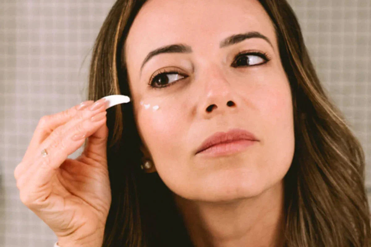 En kvinna smörjer in Dagkräm - CBD + C-vitamin i ansiktet.