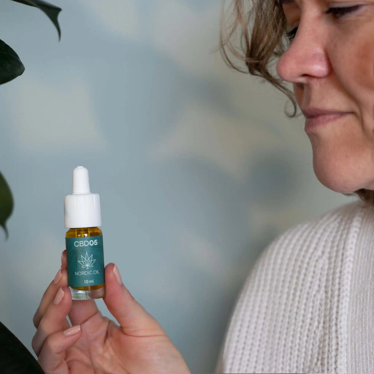 Kvinna som håller en flaska CBD Aroma Oil 5%
